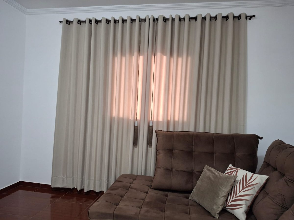 Cortina no varão com ilhós instalada numa sala